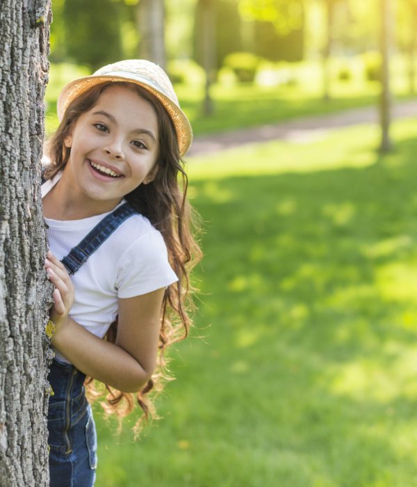 smiley-girl-hiding-tree